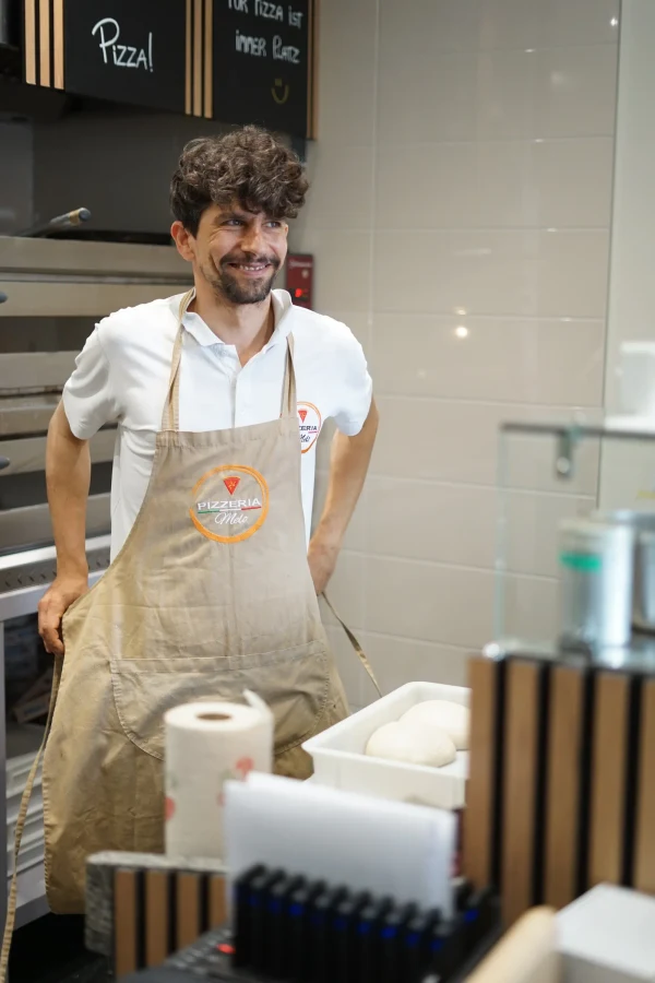 Carmello von Pizzeria Melo mit seiner Schürze in der Pizzaküche
