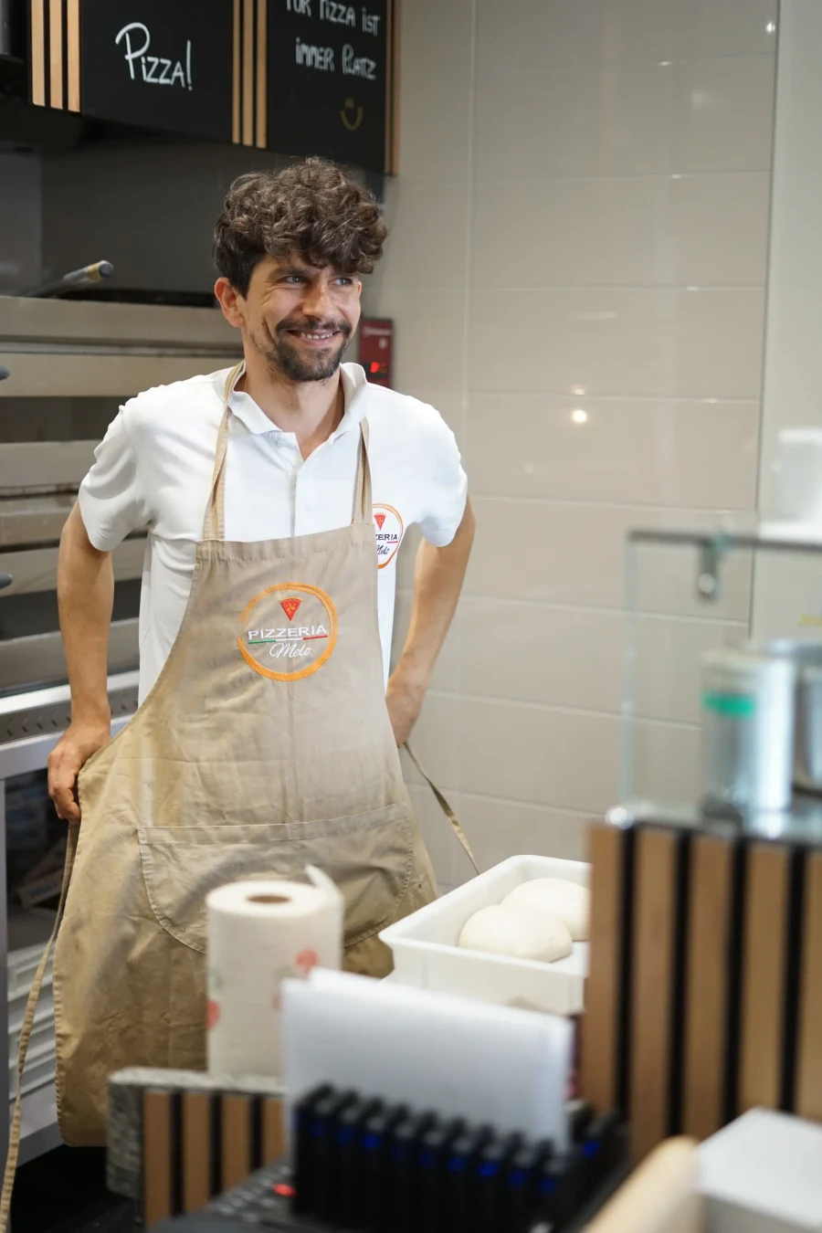 Carmello von Pizzeria Melo mit seiner Schürze in der Pizzaküche